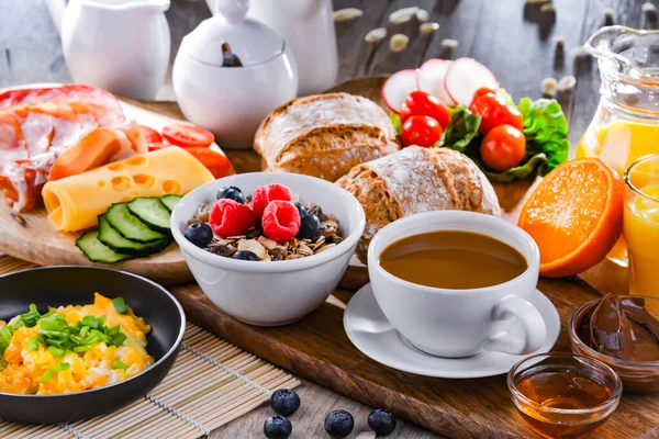 Kahvaltının yanında kahve, portakal suyu, omlet, tahıl, jambon ve peynir..