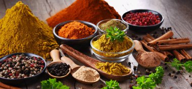 Ahşap mutfak masasında değişik baharatlar var..