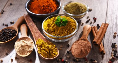 Ahşap mutfak masasında değişik baharatlar var..