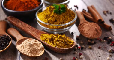 Ahşap mutfak masasında değişik baharatlar var..