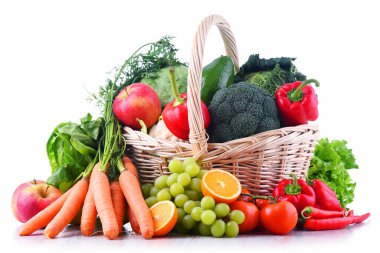 Hasır sepetin içindeki taze organik meyve ve sebzeler beyaza izole edilmiş.