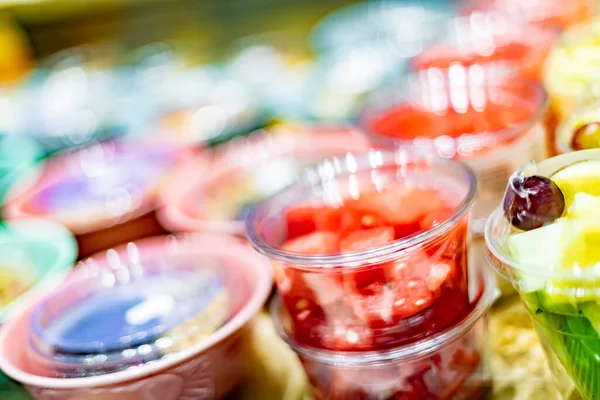 Pre-packaged fruit salads displayed in a commercial refrigerator