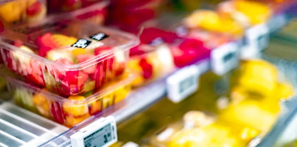 Packages with fresh fruits displayed in a commercial refrigerator