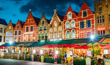 BRUGES, BELGIUM - 22 AUG 2022: Belçika 'nın Flaman Bölgesi' ndeki tarihi pazar meydanının mimarisi, gün batımından sonra