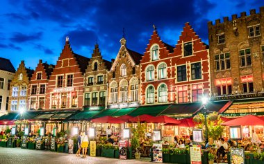 BRUGES, BELGIUM - 22 AUG 2022: Belçika 'nın Flaman Bölgesi' ndeki tarihi pazar meydanının mimarisi, gün batımından sonra