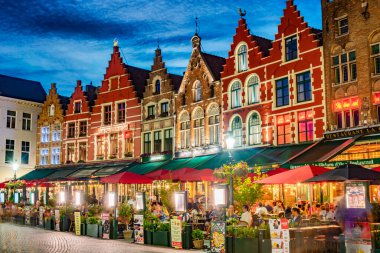 BRUGES, BELGIUM - 22 AUG 2022: Belçika 'nın Flaman Bölgesi' ndeki tarihi pazar meydanının mimarisi, gün batımından sonra