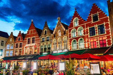BRUGES, BELGIUM - 22 AUG 2022: Belçika 'nın Flaman Bölgesi' ndeki tarihi pazar meydanının mimarisi, gün batımından sonra