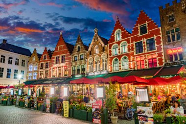 BRUGES, BELGIUM - 22 AUG 2022: Belçika 'nın Flaman Bölgesi' ndeki tarihi pazar meydanının mimarisi, gün batımından sonra