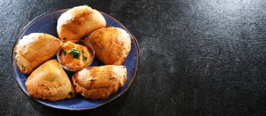 Bir tabak fırında pierogi ile kompozisyon.