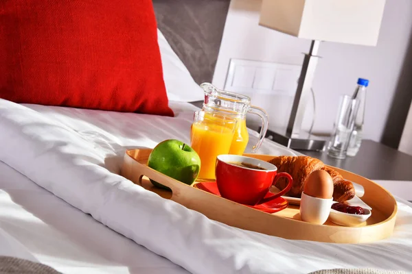 Breakfast on tray in bed in hotel room.