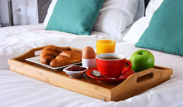 Breakfast on tray in bed in hotel room.