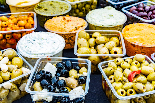 Olives in plastic boxes put up for sale in the store.