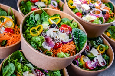 Yuvarlak karton kutular ve önceden paketlenmiş sebze salataları satışa hazır.
