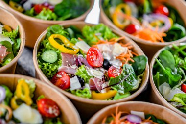 Yuvarlak karton kutular ve önceden paketlenmiş sebze salataları satışa hazır.