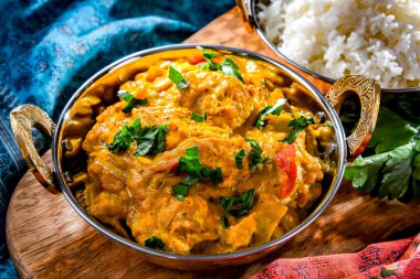 Hint karahi kaplarında servis edilen pirinçli körili tavuk..