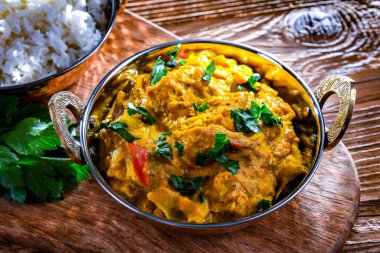 Hint karahi kaplarında servis edilen pirinçli körili tavuk..