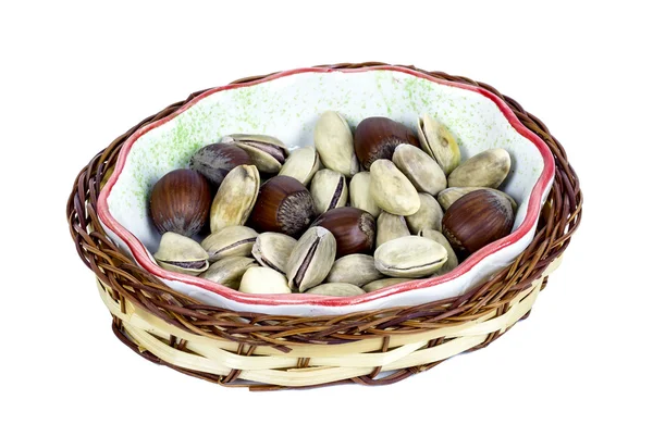 Hazelnuts and pistachios in a wicker basket — Stock Photo, Image