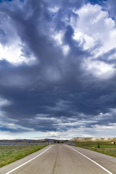 Estrada de asfalto borrada com nuvens — Fotografia de Stock