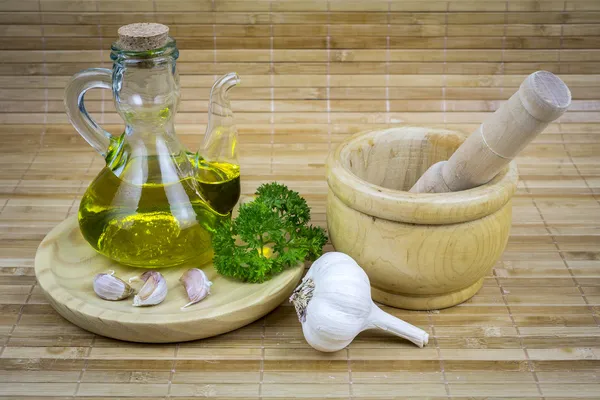 Stilleben med olivolja, grönsaker på bord av trä — Stockfoto