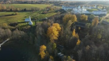 Gölün kıyısındaki Leningrad bölgesinin Pokrovsko-Tervenichesky manastırı. Güz manzarasının güzel bir günbatımı ve Ortodoks manastırı olan bir videosu..