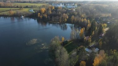 Gölün kıyısındaki Leningrad bölgesinin Pokrovsko-Tervenichesky manastırı. Güz manzarasının güzel bir günbatımı ve Ortodoks manastırı olan bir videosu..