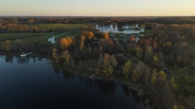 Gölün kıyısındaki Leningrad bölgesinin Pokrovsko-Tervenichesky manastırı. Güz manzarasının güzel bir günbatımı ve Ortodoks manastırı olan bir videosu..