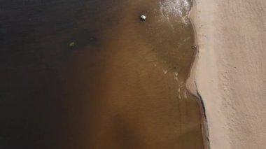 Kumlu sahil ve su yüzeyinin havadan çekilmiş görüntüleri. Plaj tatili kavramı. Renkli Yelkenli Şampanya ve Altın Kısmet.