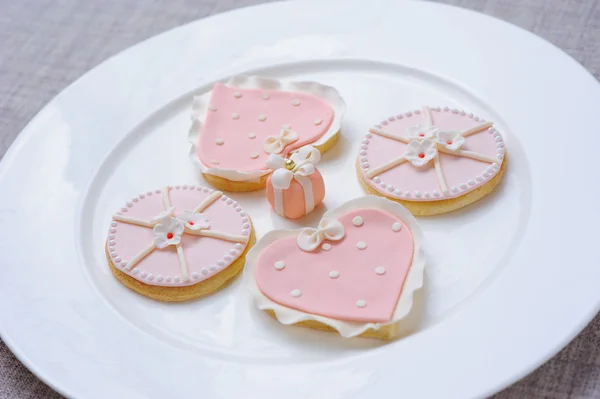 Many pink cookies on a white plate — Stock Photo, Image