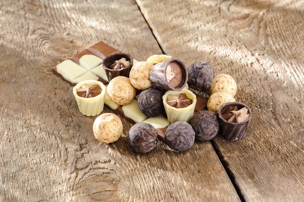 Chocolates y chocolate en una canasta sobre una mesa de madera —  Fotos de Stock