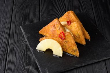 Siyah ahşap arka planda ananaslı kızarmış tofu..