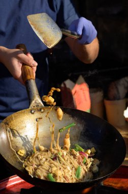 Şef sokak yemekleri festivalinde Çin eriştesi pişiriyor.