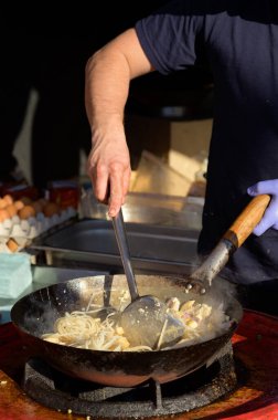 Şef sokak yemekleri festivalinde Çin eriştesi pişiriyor.