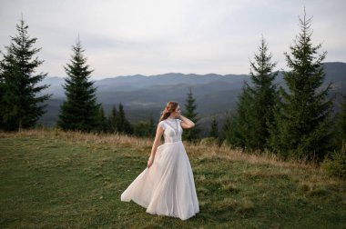 Dağların arkasında beyaz bir gelinlik içinde güzel bir gelin..