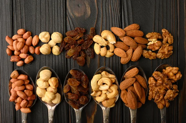 Hazelnut Cashews Raisins Almonds Peanuts Walnuts Silver Spoons Rustic Background — Stock Photo, Image
