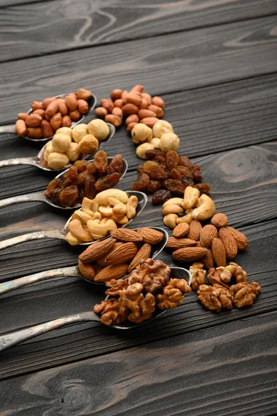 Hazelnut Cashews Raisins Almonds Peanuts Walnuts Silver Spoons Rustic Background — Stock Photo, Image