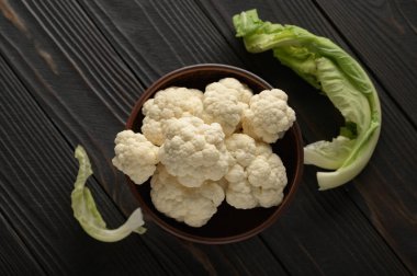 Ahşap zemin üzerinde çiğ, taze organik karnabahar. Sağlıklı beslenme, düşük karbonhidrat diyeti