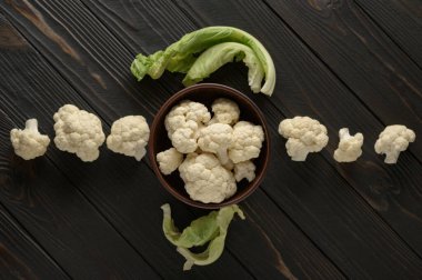 Ahşap zemin üzerinde çiğ, taze organik karnabahar. Sağlıklı beslenme, düşük karbonhidrat diyeti