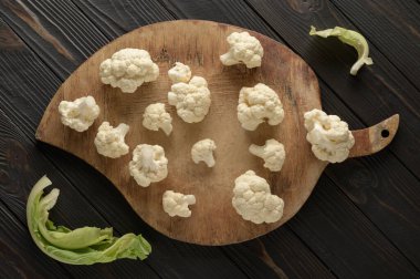 Ahşap zemin üzerinde çiğ, taze organik karnabahar. Sağlıklı beslenme, düşük karbonhidrat diyeti