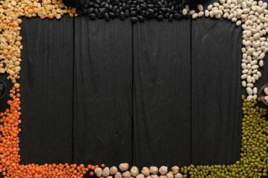 Legumes, düz tepe çekim koyu kırsal ahşap arka plan üzerinde metin için bir yer ile