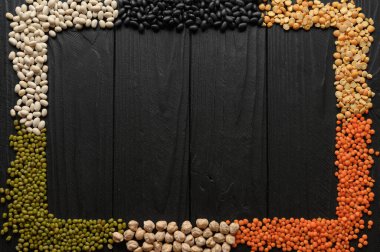 Legumes, düz tepe çekim koyu kırsal ahşap arka plan üzerinde metin için bir yer ile