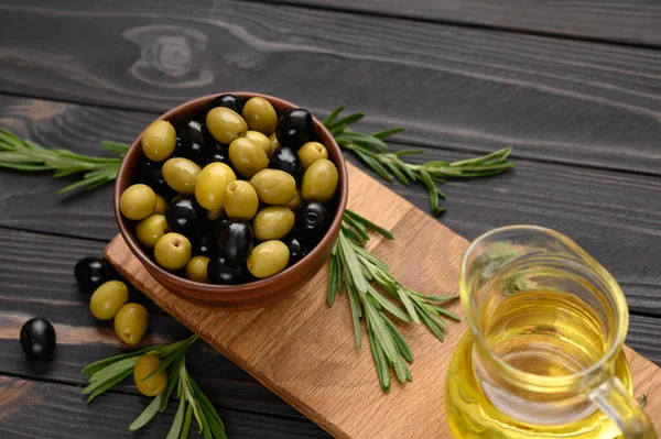 Black and green olives on a dark wooden rustic background.