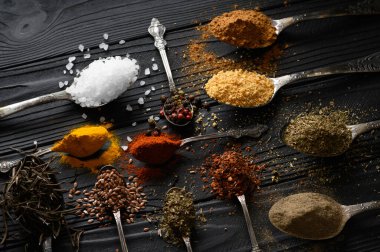 Colorful various herbs and spices for cooking on dark wooden rustic background