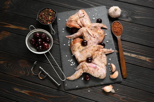 Marinated chicken wings with sweet cherry on a rustic wooden background