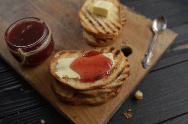 Ev yapımı çilek reçelli tost ekmeği ve kahvaltıda ya da kahvaltıda tereyağlı köy masası..