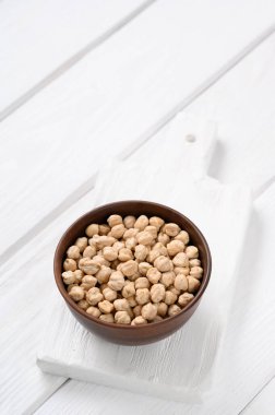 Beyaz ahşap arka planda pişmemiş bezelyeler.