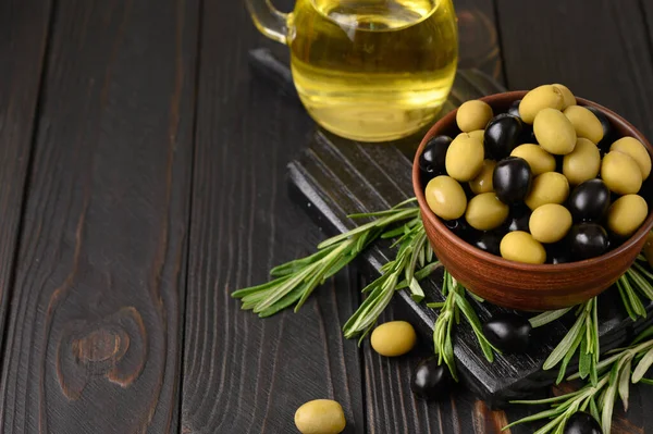 Black and green olives on a dark wooden rustic background.