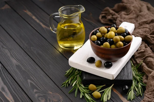 Black and green olives on a dark wooden rustic background.