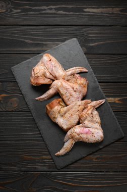 Kırsal ahşap arka planda marine edilmiş tavuk kanatları..