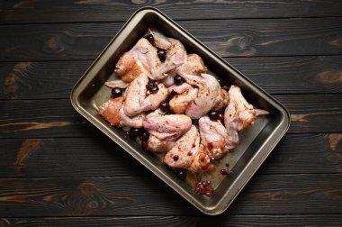 Kırsal ahşap arka planda vişneli tavuk kanadı.