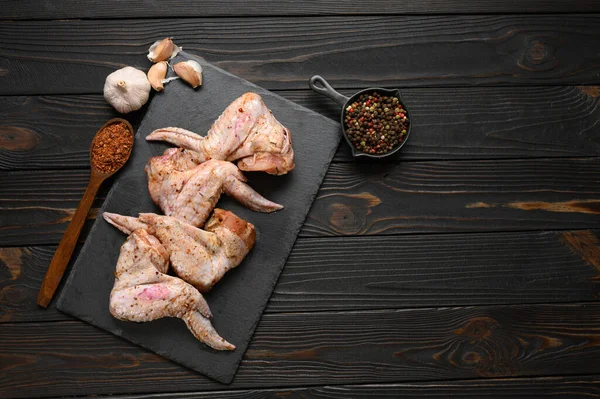 Marinated chicken wings on a rustic wooden background.